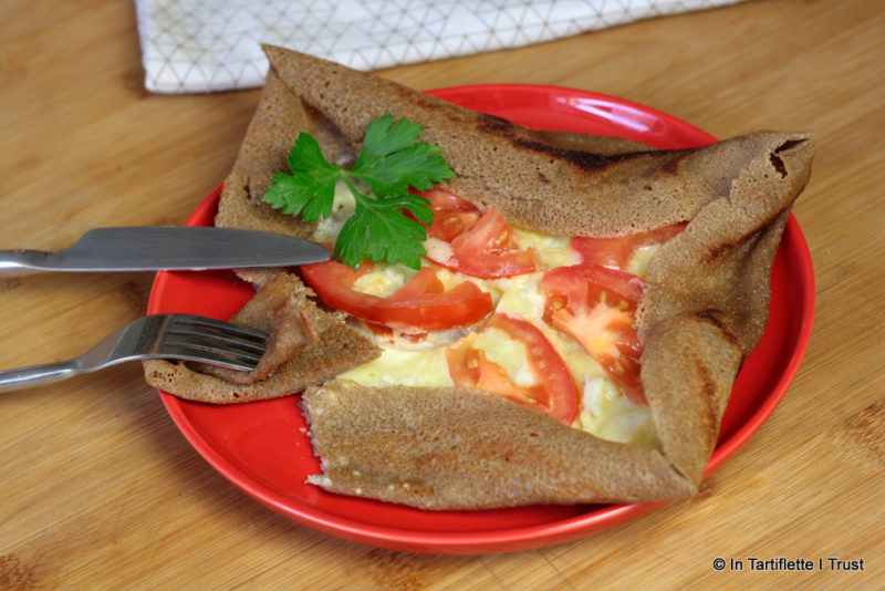 Galette de blé noir à la crème, chèvre, emmental et tomates